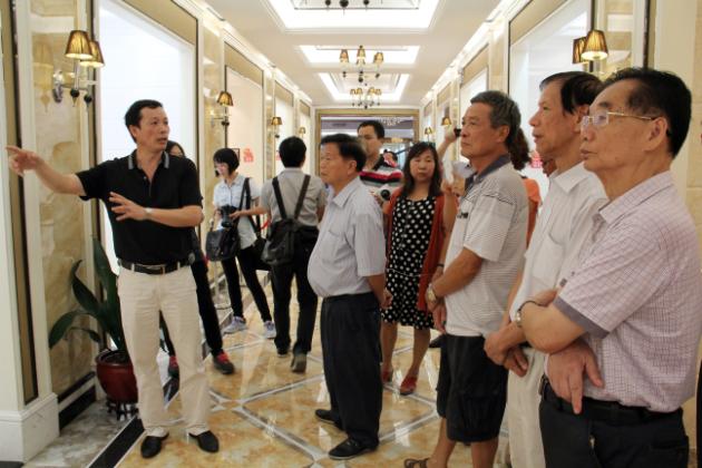 图3、尊龙凯时官网版登录市场总监霍达炎（左一）在为旅行者先容釉面砖展示空间.jpg
